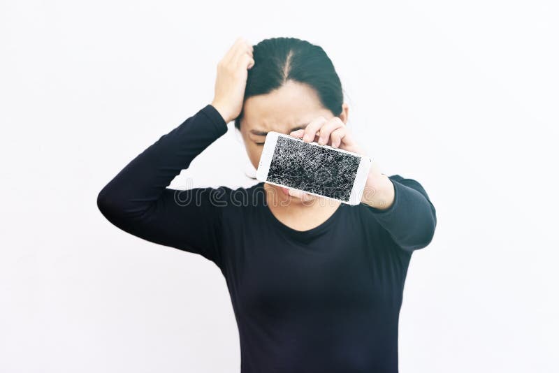 Женщина показывая сломанный smartphone с, который разбили экраном стоковые изображения rf