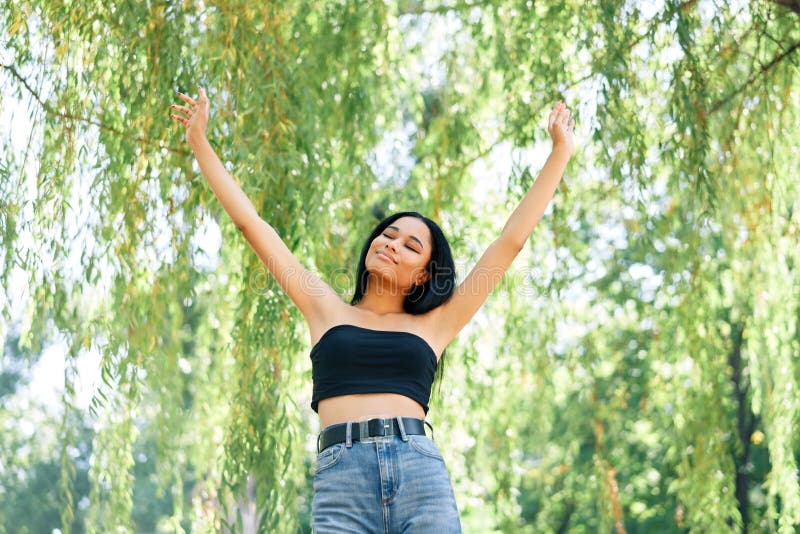 Freedom happy afro american woman with arms up relax in park. success, fun, win concept. Freedom happy afro american woman with arms up relax in park. success, fun, win concept