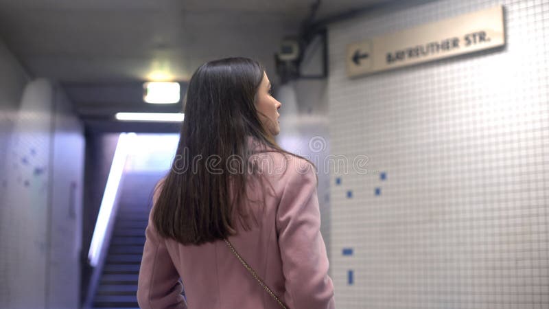 Женщина смотря указатель улицы в подполье, туристе потеряла в большом неизвестном городе стоковые изображения Женщина смотря указатель улицы в подполье, туристе потеряла в большом неизвестном городе стоковые изображения