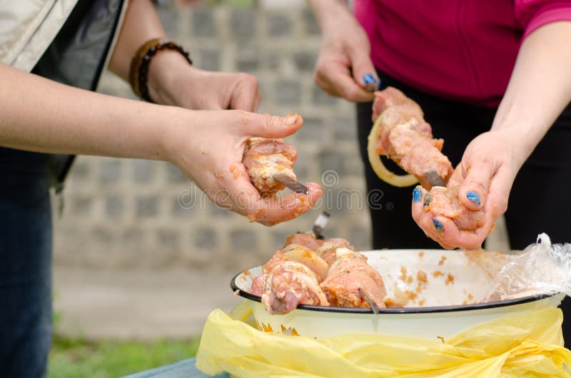 Женщины делая kebabs мяса для барбекю стоковое изображение rf Женщины делая kebabs мяса для барбекю стоковое изображение rf