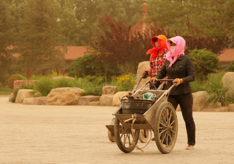 2 женщины идя на улицу во время пыльной бури, фарфора