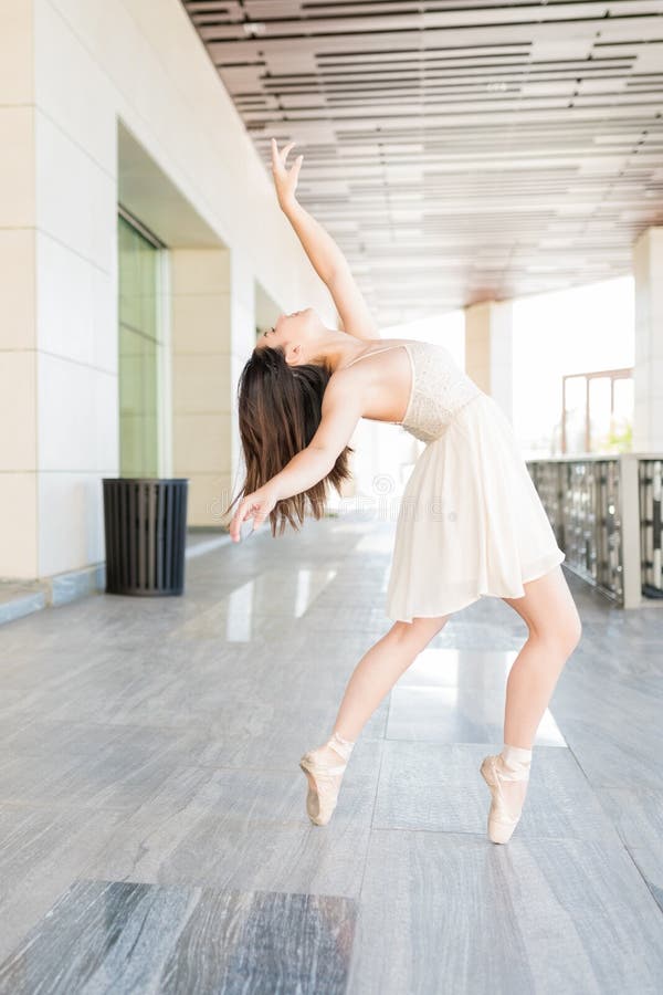 Gorgeous ballerina rehearsing dance routine on street. Gorgeous ballerina rehearsing dance routine on street