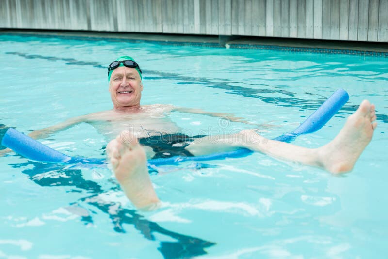 Portrait of cheerful mature man swimming with pool noodle. Portrait of cheerful mature man swimming with pool noodle