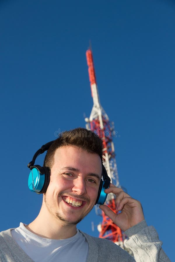 Жизнерадостный молодой человек с стороной Antena наушников стоковые фотографии rf
