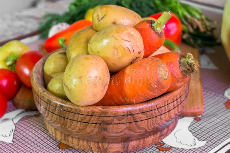 жизнь кухни все еще Свежие сырцовые морковь и картошка в деревянной плите на таблице стоковое фото жизнь кухни все еще Свежие сырцовые морковь и картошка в деревянной плите на таблице стоковое фото