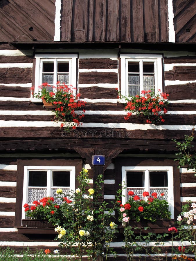 Beautiful historic log house with flowers in windows. Beautiful historic log house with flowers in windows.