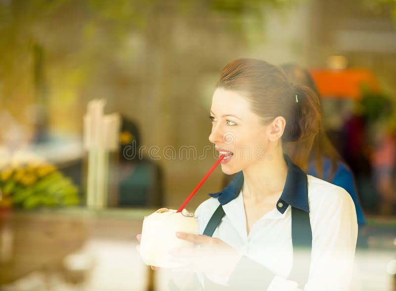 Здоровая молодая женщина наслаждаясь ее smoothie в баре сока стоковая фотография