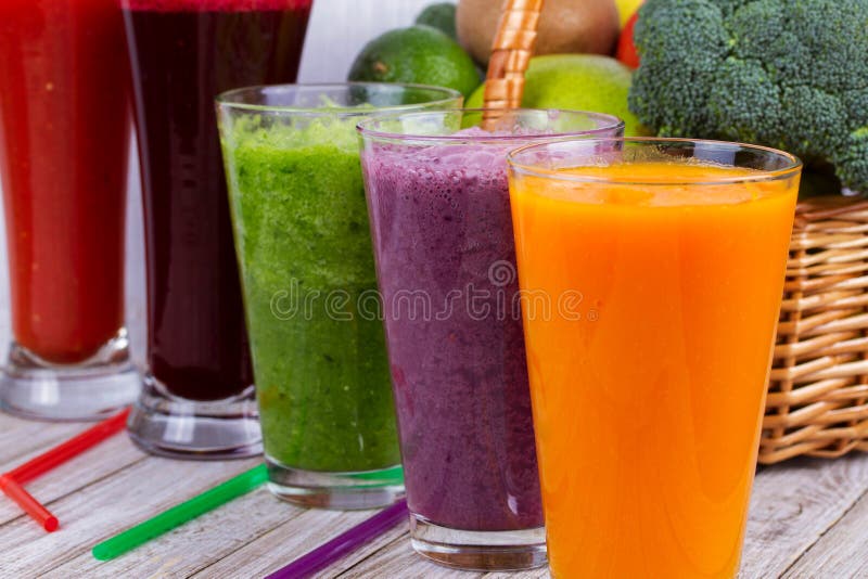 Здоровые красочные Smoothies с фруктами и овощами против деревенской деревянной предпосылки стоковые фотографии rf