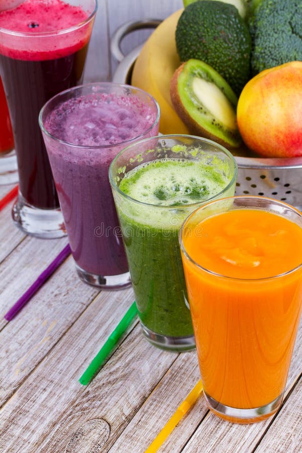 Здоровые красочные Smoothies с фруктами и овощами против деревенской деревянной предпосылки стоковая фотография rf