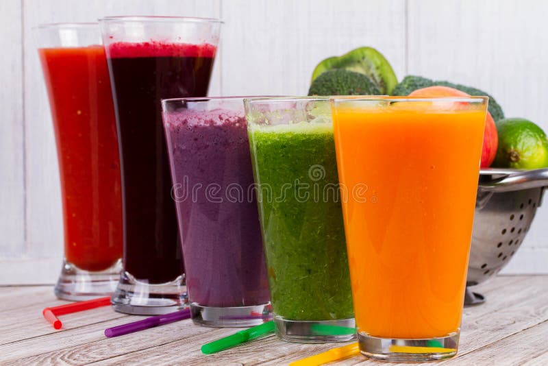 Здоровые красочные Smoothies с фруктами и овощами против деревенской деревянной предпосылки стоковые изображения rf