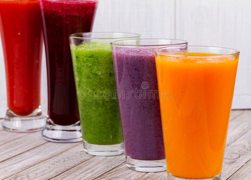 Здоровые красочные Smoothies с фруктами и овощами против деревенской деревянной предпосылки стоковое фото