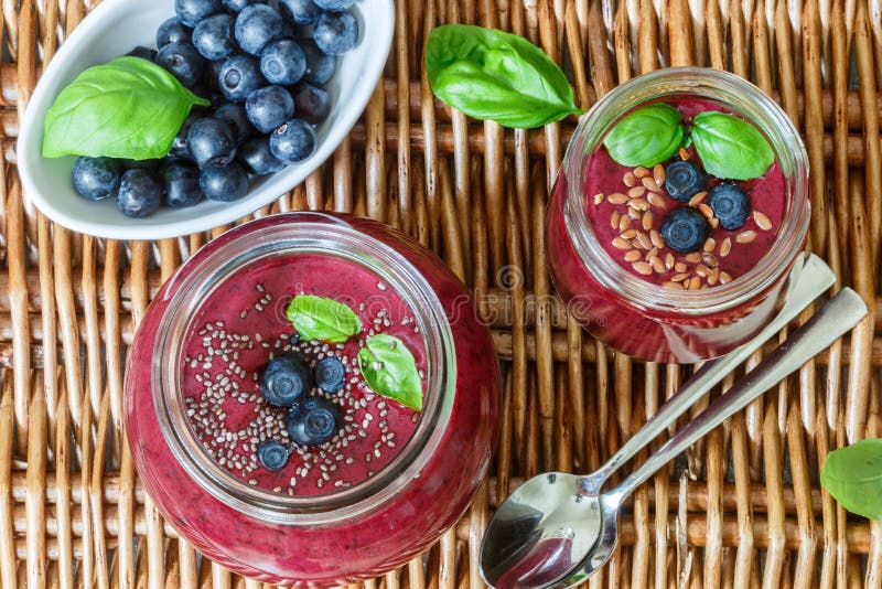 Здоровый десерт лета завтрака Smoothies голубик с семенами Chia и семенем льна и свежими сочными ягодами стоковые изображения Здоровый десерт лета завтрака Smoothies голубик с семенами Chia и семенем льна и свежими сочными ягодами стоковые изображения