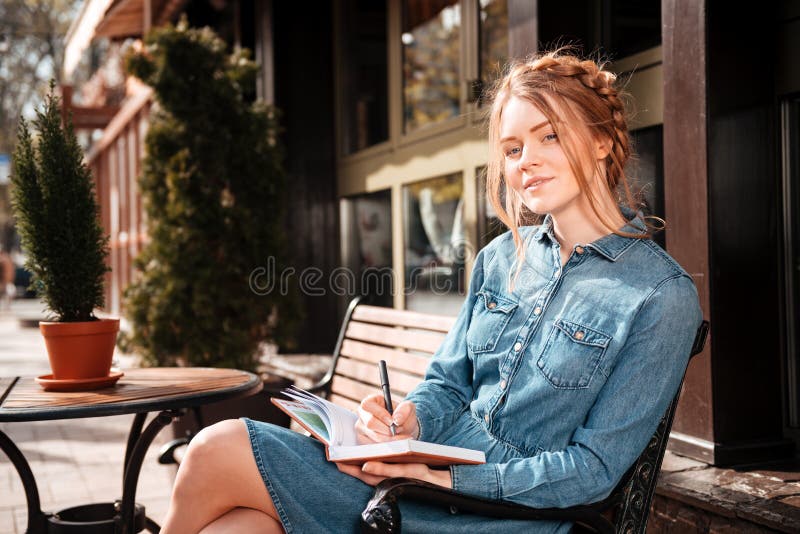 Заботливая книга readng женщины и мечтать на beanch outdoors стоковое фото Заботливая книга readng женщины и мечтать на beanch outdoors стоковое фото