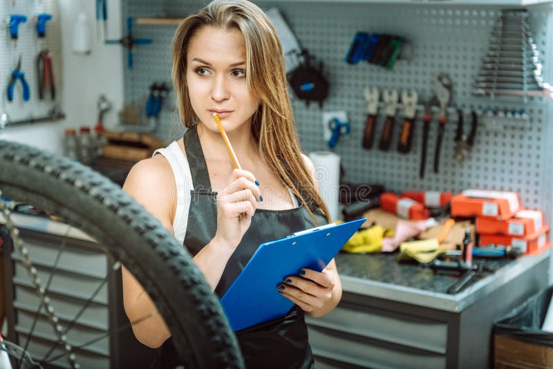 Заботливый craftswoman принимая примечания в мастерской стоковые изображения
