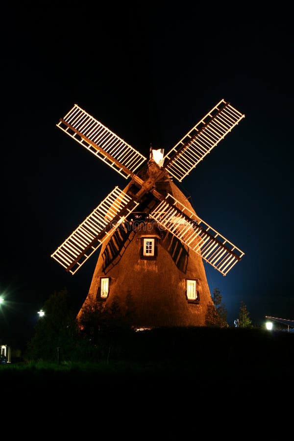 A windmill illuminated by lights at night. A windmill illuminated by lights at night.