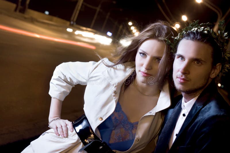 Young woman and man standing on illuminated street at dark night. Young woman and man standing on illuminated street at dark night