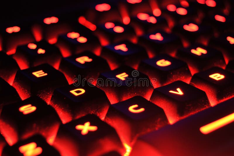 An abstract closeup of a red illuminated backlit glowing computer keyboard. An abstract closeup of a red illuminated backlit glowing computer keyboard