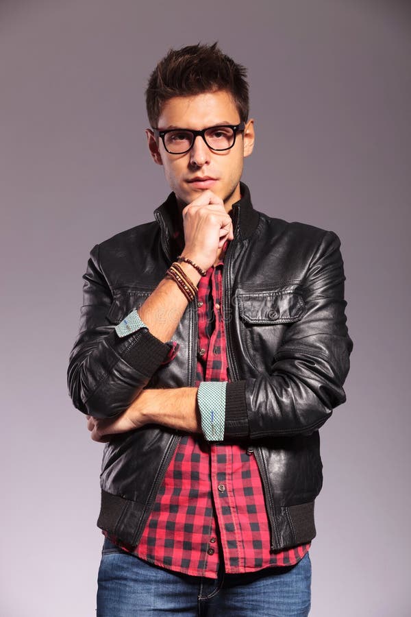 Portrait of a pensive young man with leather jacket and glasses. Portrait of a pensive young man with leather jacket and glasses