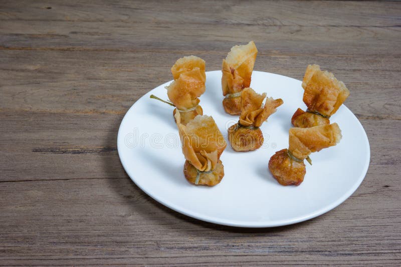 Зажаренные wonton или схват Toong на деревянной предпосылке стоковое изображение rf Зажаренные wonton или схват Toong на деревянной предпосылке стоковое изображение rf
