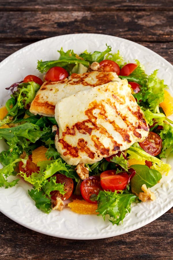 Зажаренные апельсин, томаты и салат ведьмы салата сыра Halloumi еда здоровая стоковая фотография Зажаренные апельсин, томаты и салат ведьмы салата сыра Halloumi еда здоровая стоковая фотография