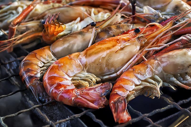 Зажаренные морепродукты креветок короля огнем и BBQ пылают Барбекю ресторана на рынке ночи стоковое изображение rf Зажаренные морепродукты креветок короля огнем и BBQ пылают Барбекю ресторана на рынке ночи стоковое изображение rf