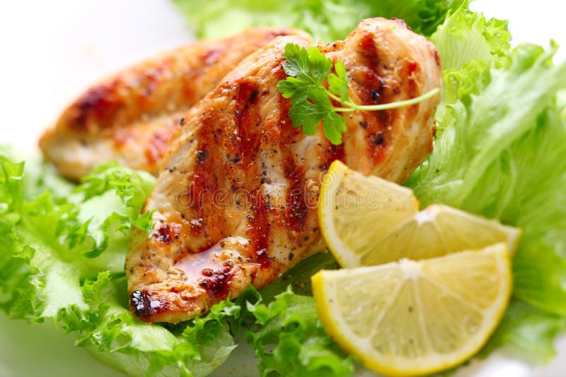 Grilled chicken breast with fresh lettuce and lemon. Grilled chicken breast with fresh lettuce and lemon