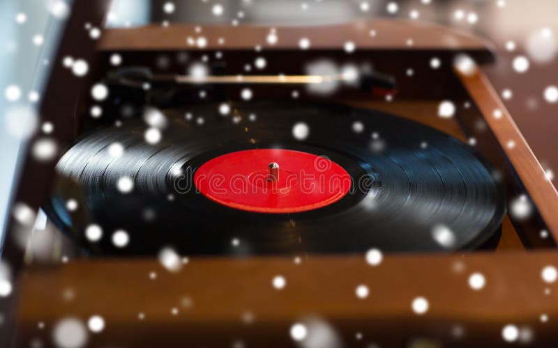 Music, technology and object concept - close up of vintage record player with vinyl disc over snow. Music, technology and object concept - close up of vintage record player with vinyl disc over snow