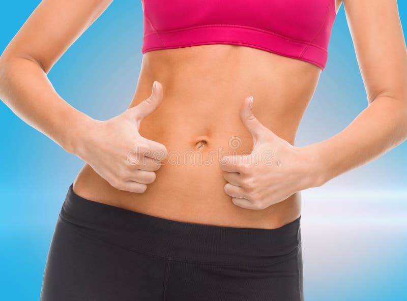 Закройте вверх женского abs и рук показывая большие пальцы руки вверх стоковое фото rf Закройте вверх женского abs и рук показывая большие пальцы руки вверх стоковое фото rf