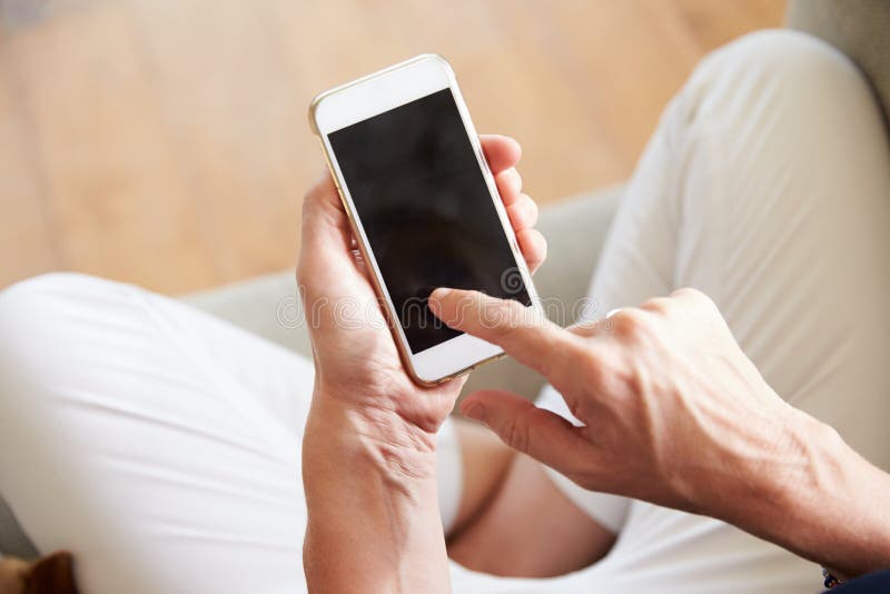 Закройте вверх женщины используя Smartphone дома стоковое фото rf