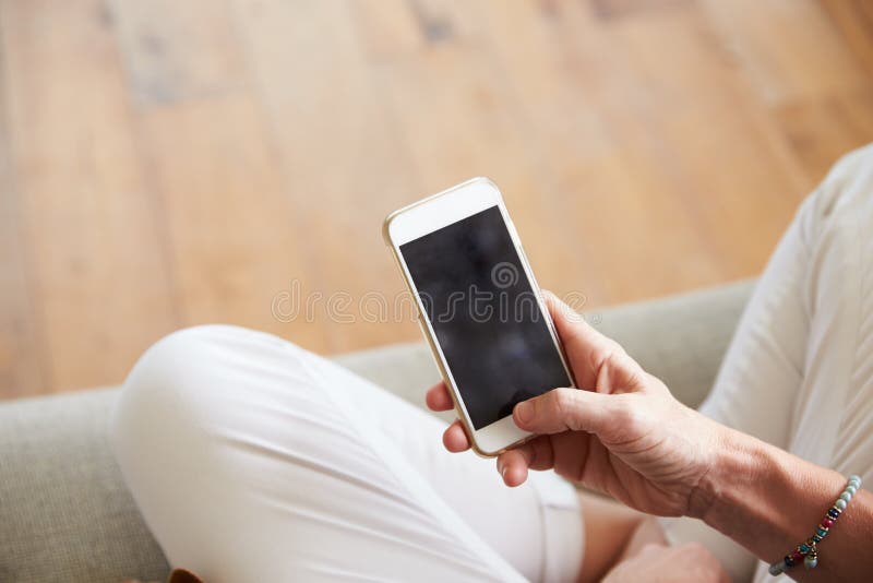 Закройте вверх женщины используя Smartphone дома стоковое изображение rf
