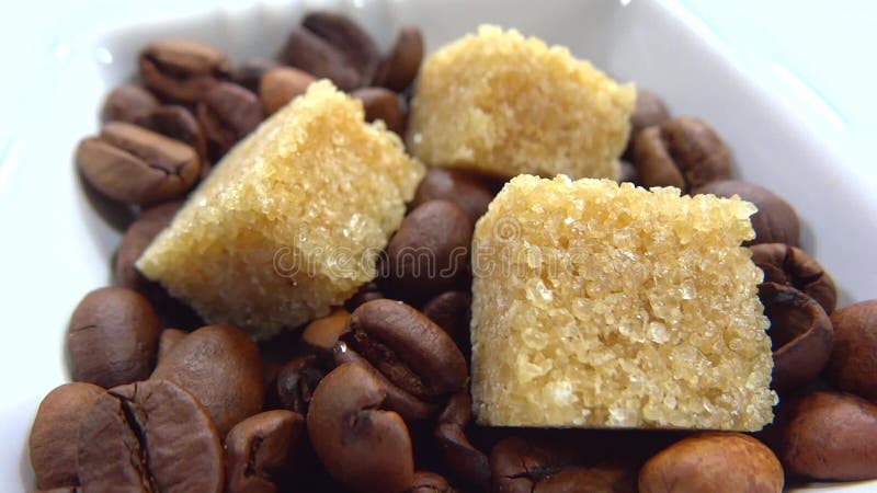 Закройте вверх кубов сахара с кофейными зернами сток-видео