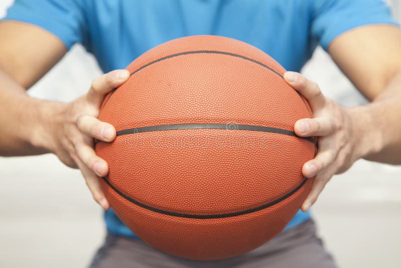 Close up of young man, midsection, holding a basketball. Close up of young man, midsection, holding a basketball