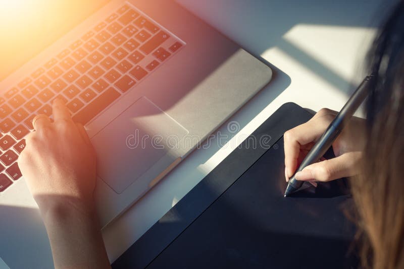 Закройте вверх по взгляду руки график-дизайнера используя цифровую ручку таблетки с солнечным светом Селективный фокус стоковые фотографии rf Закройте вверх по взгляду руки график-дизайнера используя цифровую ручку таблетки с солнечным светом Селективный фокус стоковые фотографии rf