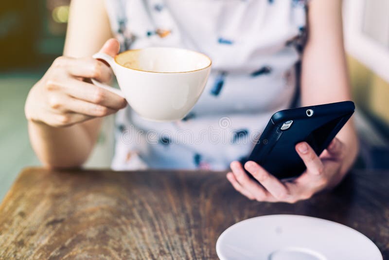Закройте вверх по женщине руки используя smartphone в кофейне стоковые фотографии rf