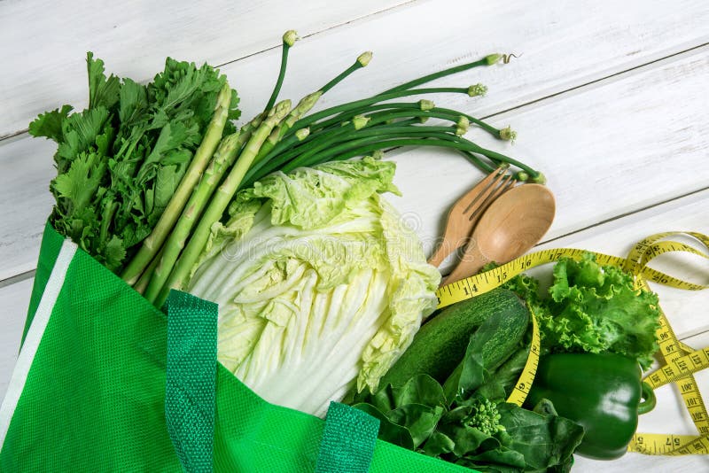 Закройте вверх по зеленой продуктовой сумке смешанных органических зеленых овощей на белых, здоровых органических зеленых походе стоковое изображение rf