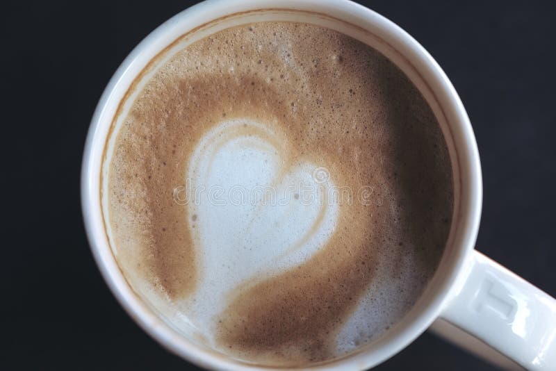 Закройте вверх по изображению горячего кофе с искусством latte сердца в белой кружке стоковые изображения Закройте вверх по изображению горячего кофе с искусством latte сердца в белой кружке стоковые изображения