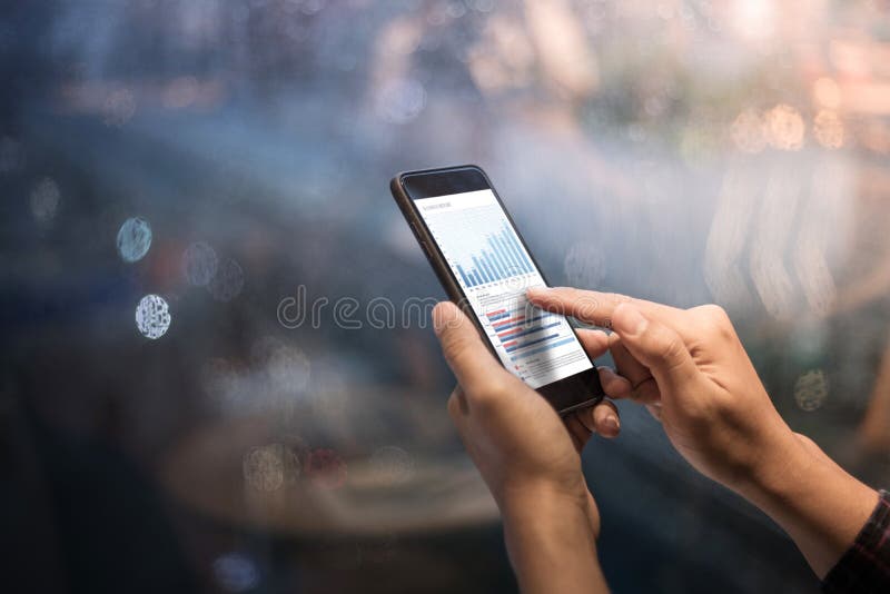 Закройте вверх по мужским рукам держа smartphone с диаграммой диаграммы стоковое фото