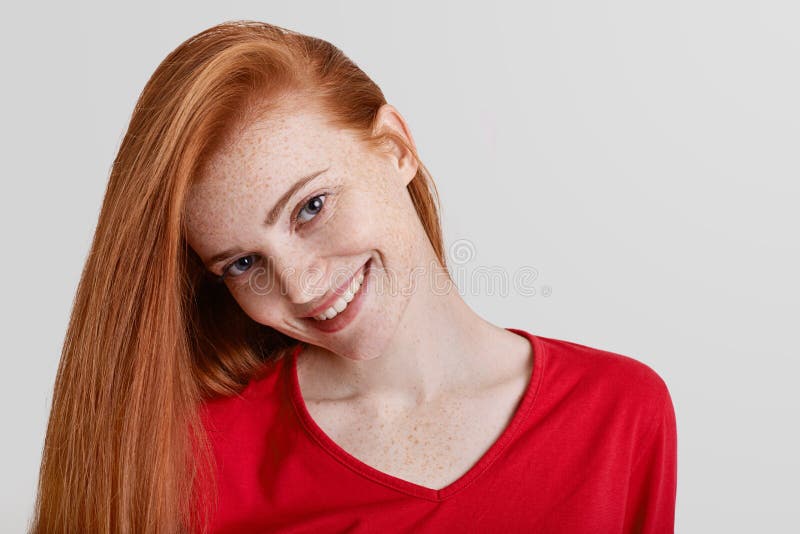 Закройте вверх по съемке счастливой freckled женщины с длинными волосами имбиря, приятной сияющей улыбкой, находящся в хорошем на стоковые изображения rf Закройте вверх по съемке счастливой freckled женщины с длинными волосами имбиря, приятной сияющей улыбкой, находящся в хорошем на стоковые изображения rf