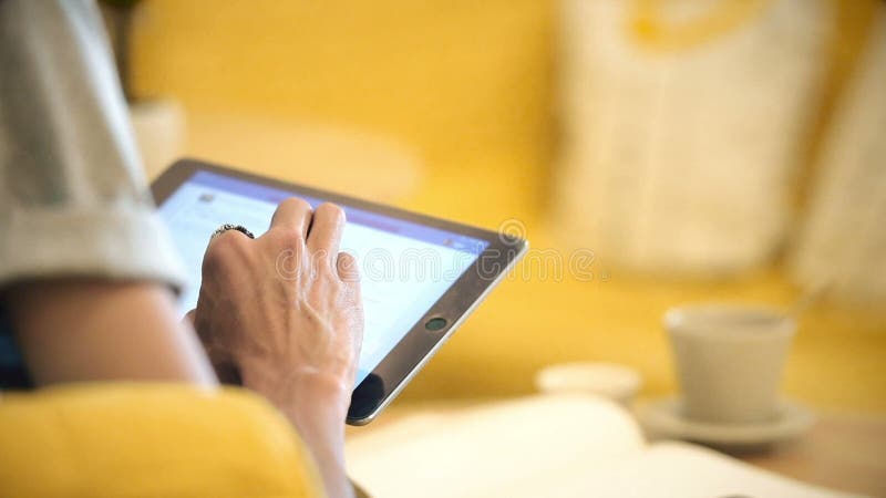 Закройте вверх по человеку используя таблетку на кафе кофе на таблице акции видеоматериалы