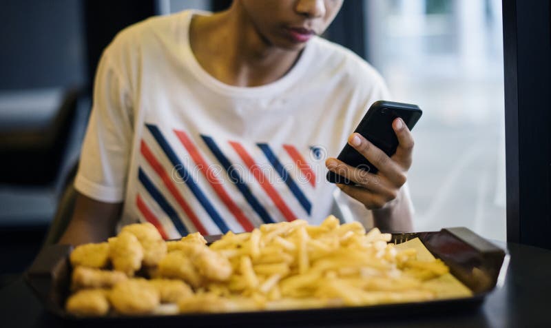 Закройте вверх подростка используя smartphone стоковые фото