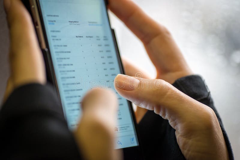 Закройте вверх рук женщины используя smartphone стоковые изображения