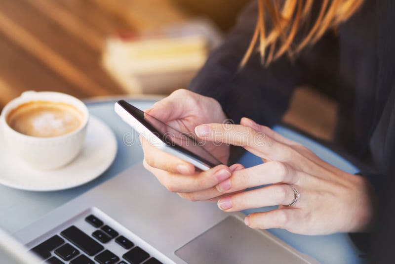 Закройте вверх рук используя передвижное применение на smartphone стоковые фото