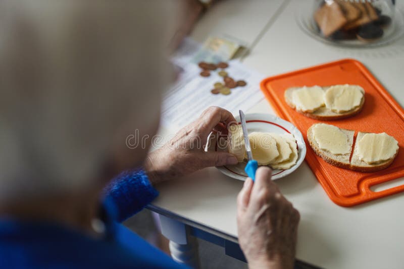 закрытие рук пожилой женщины, которая делает бутерброды на кухне стоковые изображения