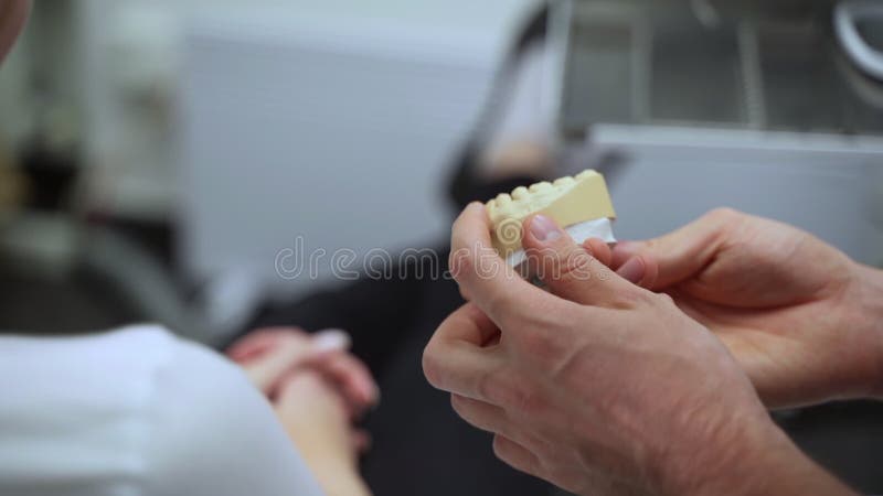 закрытое представление о мужской ортодонтистской модели челюсти и разговор с пациентом в современной клинике. акции видеоматериалы