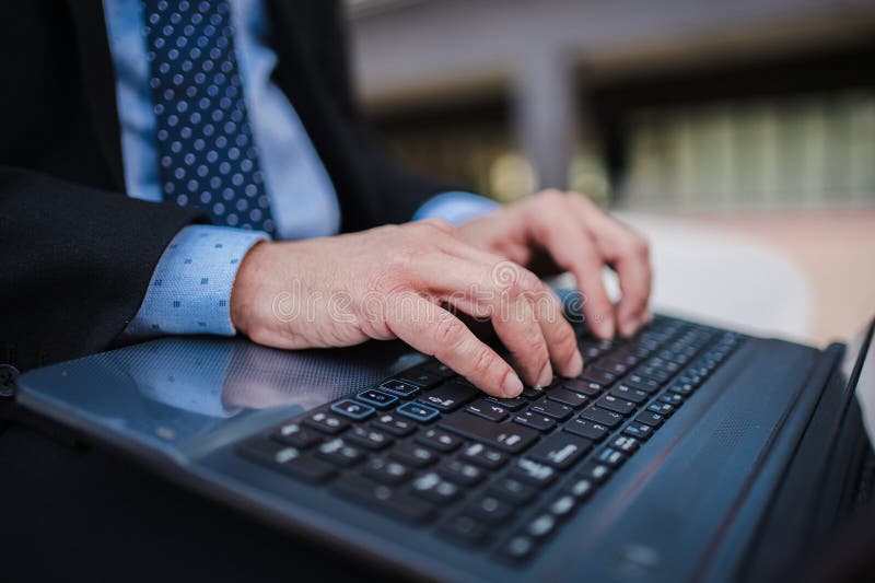 Close up business man hands typing on laptop computer keyboard, online remote working or searching information, sending e-mails or messaging sitting outside. Unrecognizable entrepreneur using internet. High quality photo. Close up business man hands typing on laptop computer keyboard, online remote working or searching information, sending e-mails or messaging sitting outside. Unrecognizable entrepreneur using internet. High quality photo