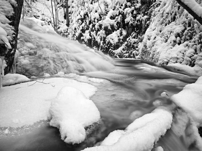 Замороженный водопад каскада, ледистые хворостины и ледистые валуны в замороженной пене быстрого потока Заводь зимы Весьма замора стоковая фотография Замороженный водопад каскада, ледистые хворостины и ледистые валуны в замороженной пене быстрого потока Заводь зимы Весьма замора стоковая фотография