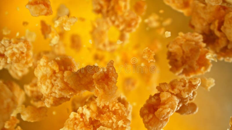заморозить движение летящих кусочков жареной курицы на цветном фоне стоковая фотография