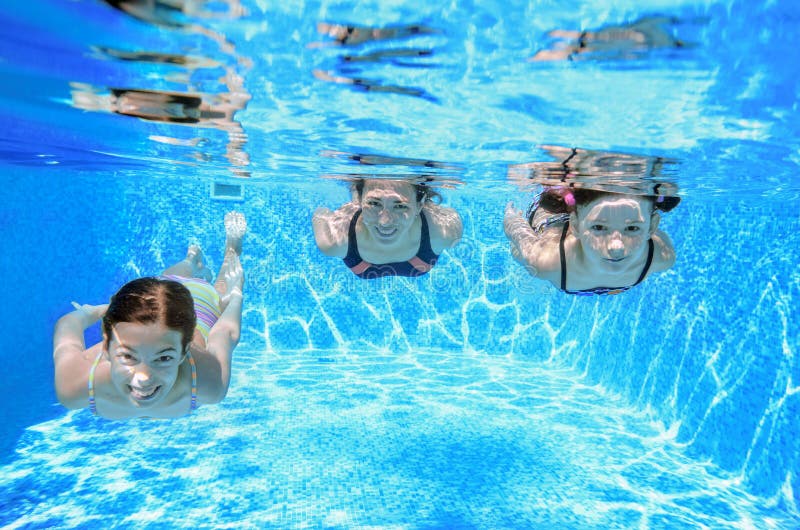 Family swimming in pool under water, happy active mother and children have fun, fitness and sport with kids on summer vacation. Family swimming in pool under water, happy active mother and children have fun, fitness and sport with kids on summer vacation
