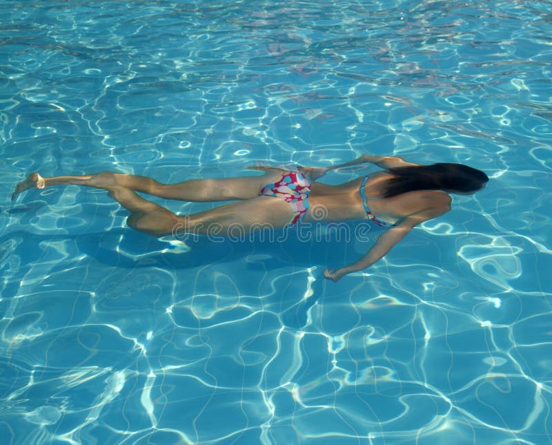 Заплывание молодой женщины под водой