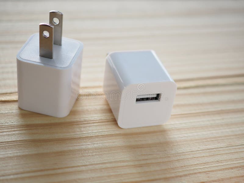 Заряжатель бело-куба Usb на деревянной доске с концепцией технологии и энергии, который нужно облегчить стоковые изображения Заряжатель бело-куба Usb на деревянной доске с концепцией технологии и энергии, который нужно облегчить стоковые изображения